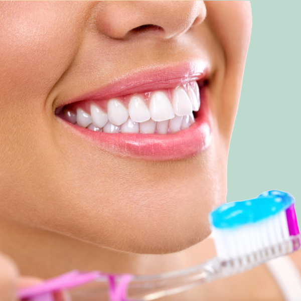 Woman Smiling with White Teeth and Holding Toothbrush