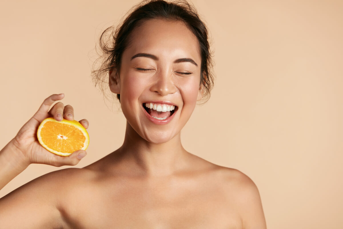 Woman Smiling with Vitamin C Orange in Hand